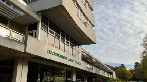 BBC A large concrete building with a green lettered county council sign on the front