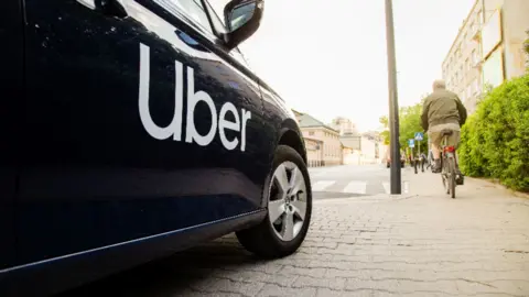 The side of a black car with the white uber logo.