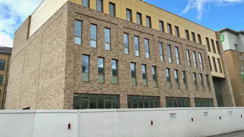 Bradford College A new square brown brick building with a row of windows and a flat roof 