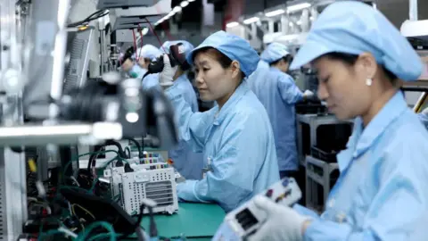 Reuters workers who wear protective clothing on a production line of intelligent automobiles Central Control Navigation Products in a factory by Beidou Intelligent Connected Vehicle Technology Co. (BICV) in the High -Tech Industrial Development Zone, Suqian, China Province