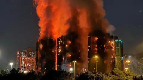 Residential towers going up in flames, with a massive cloud of flames and smoke burning upwards