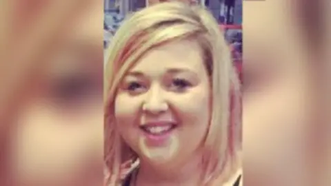 A woman smiles at the camera with blonde hair.