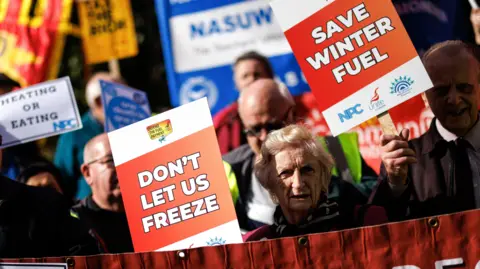 Protesters hold placards and banners while campaigning for the reversal of the winter fuel payment cuts to pensioners, which is proposed by the British government, at Old Palace Yard, in London, Britain, 7 October 2024.