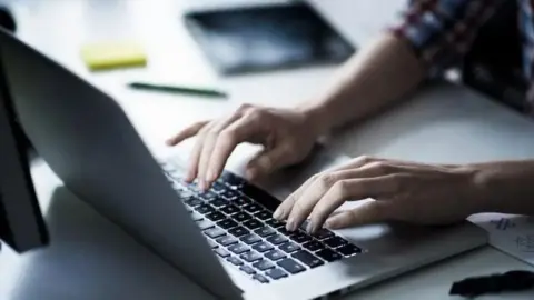 The image is a generic photo of a woman's resting on the keyboard of the laptop, on a desk.