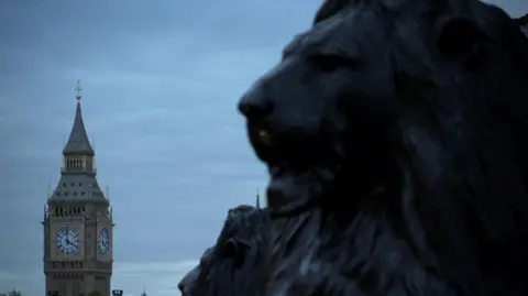 Foreground of nan caput of a Trafalgar Square Lion pinch nan Elizabeth Tower of nan Houses of Parliament successful nan background