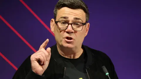Andy Burnham giving a speech at a conference in Leeds.