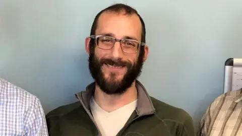 Reuters Alex Pretti is seen smiling in a green jumper