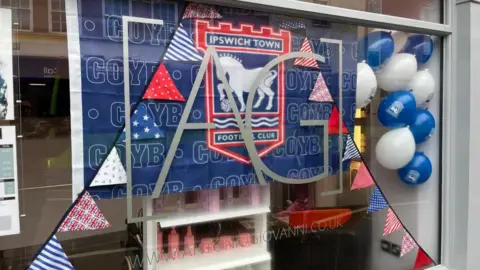 Shaun Whitmore/BBC Shop window decorated blue and white