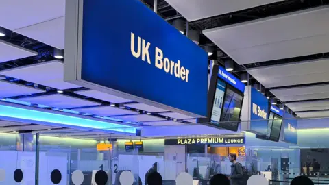NurPhoto via Getty Images UK Border sign is seen at the arrivals passport control and visa area of London Heathrow Airport