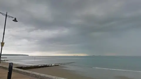 A section of the beach in Shanklin. There is a lamppost to the left of the frame and a small part of the pavement can be seen, with a small section of pebbled beach leading into the sea.