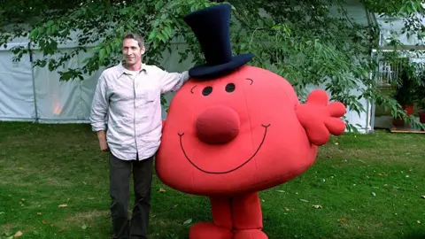 Getty Images British writer Adam Hargreaves stands next to a red Mr Man with a black hat