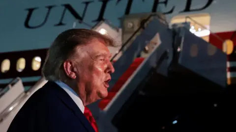 U.S. President Donald Trump speaks to members of the media after disembarking Air Force One at Joint Base Andrews, Maryland, U.S., August 11, 2026. 