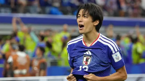 Keito Nakamura pulls his shirt when celebrating his goal