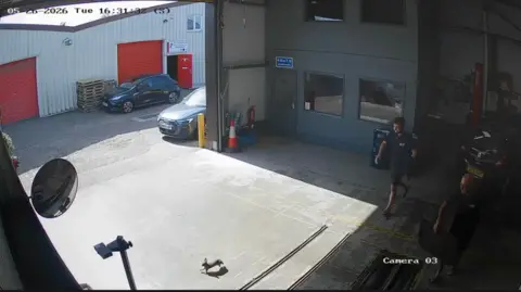 Hanningfield Motor Company A still image from CCTV footage of two mechanics chasing out a very small rabbit