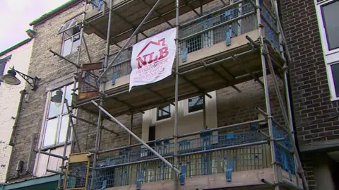 The outside of the disused house which has scaffolding around it