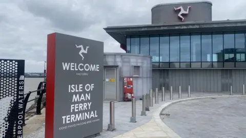 Isle of Man Steam Packet Company The new Liverpool ferry terminal, a grey building with bollards in front and a sign welcoming passengers to the left of the image 