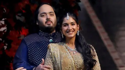 路透社 2023 年 1 月 19 日，阿纳特·安巴尼 (Anant Ambani) 和拉迪卡·麦钱特 (Radhika Merchant) 在印度孟买安巴尼安蒂拉 (Antilia) 住宅举行的红毯仪式上合影，庆祝他们的订婚。