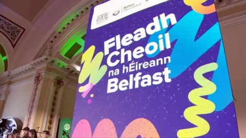 A purple sign that reads Fleadh Cheoil na hEireann Belfast