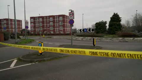 A close up of yellow crime scene tape which surrounds a roundabout close to where the crash took place.