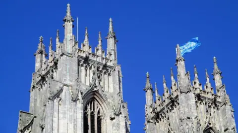 The top part of the west side of the minster with the pinnacles on top of the roof.