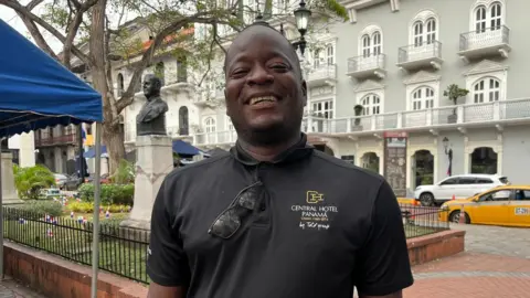 Andre Howell, a hotel worker in the historic centre of Panama City. He is smiling into the camera and wearing a black polo shirt.