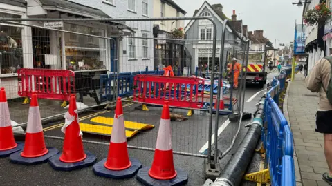 JULIA GREGORY/BBC Barriers around the sinkhole on West Street