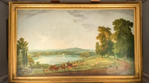National Trust Betsy Ogilvie A painting of a rural setting which includes a lake and some trees. It is illuminated between white pillars and white walls.