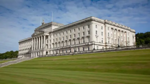 Getty Images Stormont Parliament Buildings pictured from the outside on a sunny day. It is a cream stone buidling.