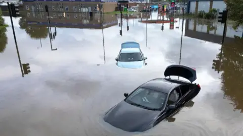 Cars floating in floodwater in Derby after the River Derwent burst its banks during storm Babet on October 21, 2023.