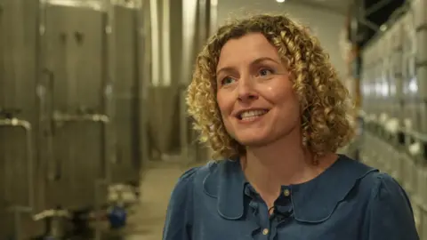 Emma Thackray is standing inside the warehouse for Hip Pop as she is being interviewed.