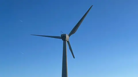 BBC Wind turbine seen against a background of bright blue sky