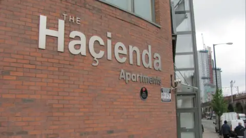 Outside of the Hacienda Apartments building: the outside reads 'Hacienda Apartments'.