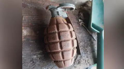 Danny Wyatt A hand grenade on a wooden shelf in a shed.