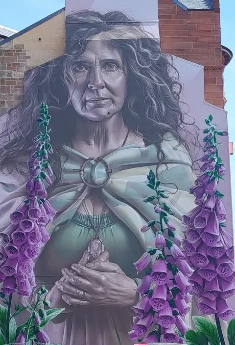 Glasgow City Council A mural of a woman, painted on the wall of a city building
