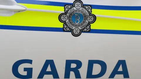 The door of a car with a "Garda" decal printed on it.