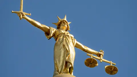 A close-up image of the golden statue of Lady Justice.