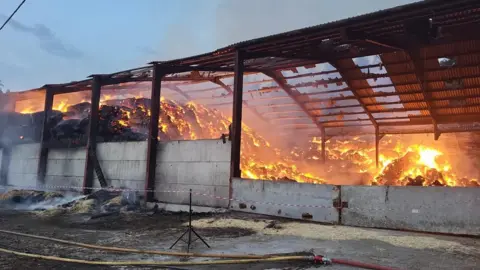 DWFRS Hay bales fully alight in a barn.