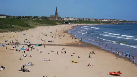 People enjoying the warm Spring Bank Holiday weather at Tynemouth Longsands in North Tyneside.