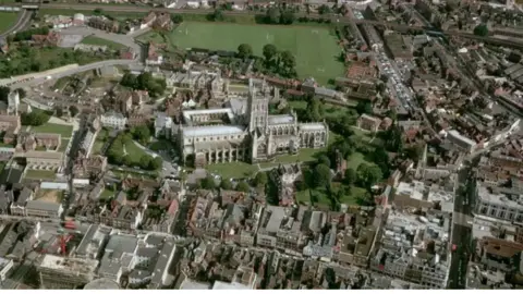 Drone shot of Gloucester cathedral and surrounding homes and roads.