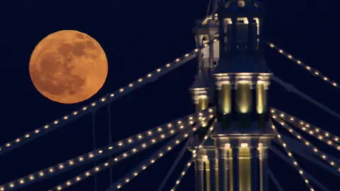 Getty Images The Full moon rises over Albert Bridge on February 7, 2012 in London, England. Albert Bridge is said to be one of the most romantic bridges in London, and will be the start point for the flotilla of boats that will make their way along the Thames as part of the Queen's Diamond Jubilee celebration.