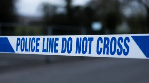 Police barrier tape in the UK - stock photo