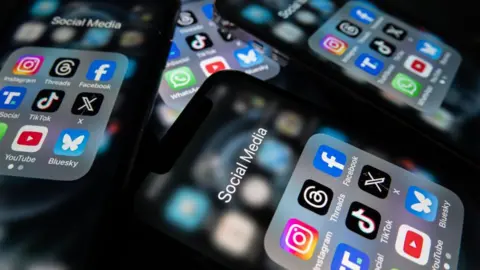 Getty Images A number of smart phone screens with social media apps on them.