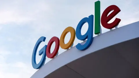 Reuters A close-up of the Google logo displayed on a Google building against the backdrop of a blue sky.