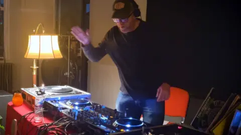 Male DJ dances while on the decks