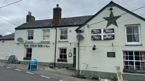 The Star Inn. It is a traditional two-storey English pub by a road, with a rendered exterior in a pale green colour and a slate roof.