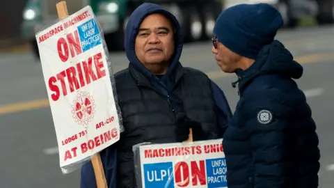 Getty Images Boeing workers on a picket line near the entrance to a Boeing facility in Seattle, Washington. 