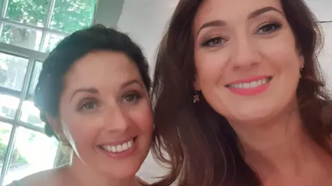 Kathy McCaughey Two women with brown hair smiling for a selfie.
