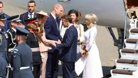 PA Media On an airport tarmac, at the base of white steps leading from a small plane, Emmanuel Macron holds Catherine's hand as they speak, while a step behind them, Prince William speaks to Brigitte.