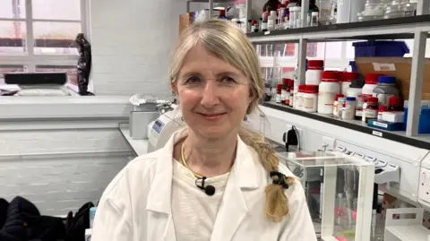 Professor Mandy Fader in white coat in a lab at the University of Southampton
