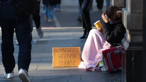 A homeless person begs on the streets of London.